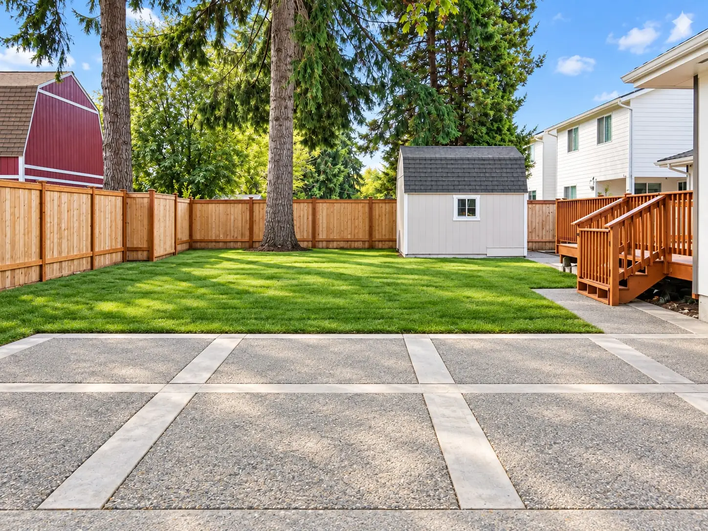 Fenced back lawn with a patio and garden shed