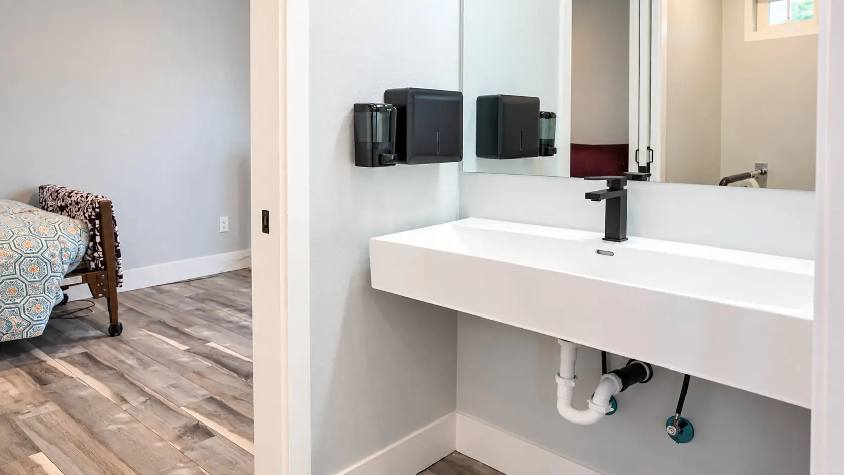 Wall-mounted sink with soap and towel dispensers