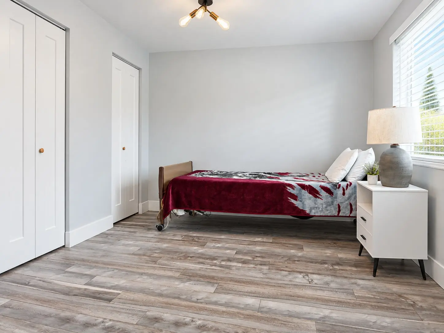 Bedroom with closet doors, a single bed and a window