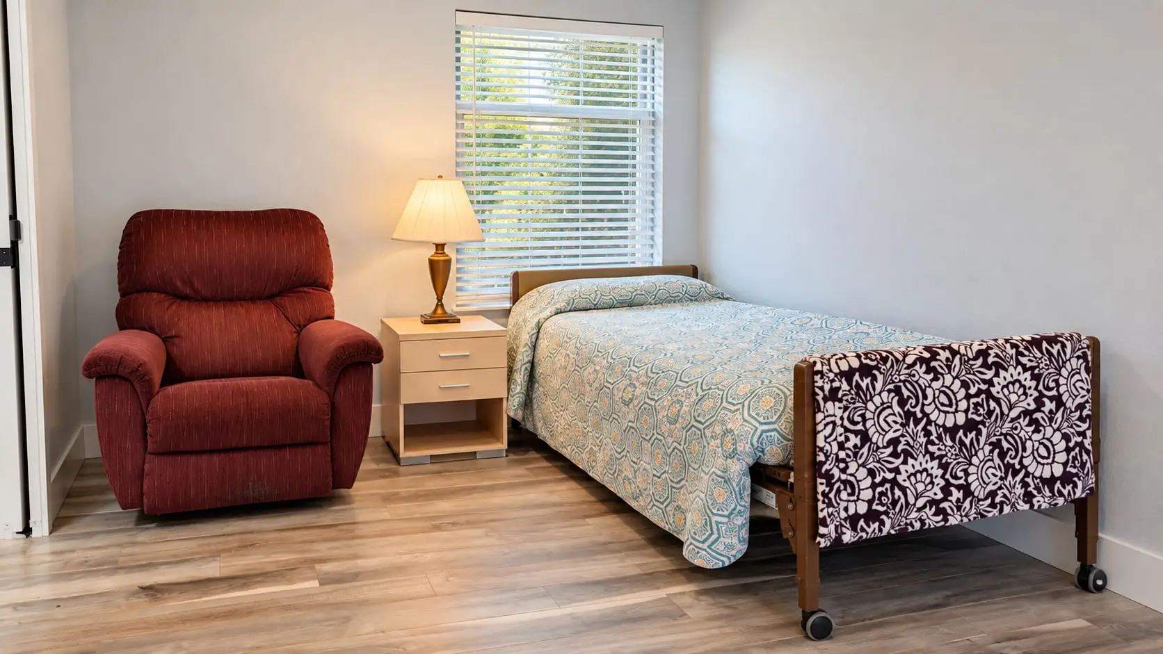 Bedroom with a single bed, a red recliner and a bedside lamp