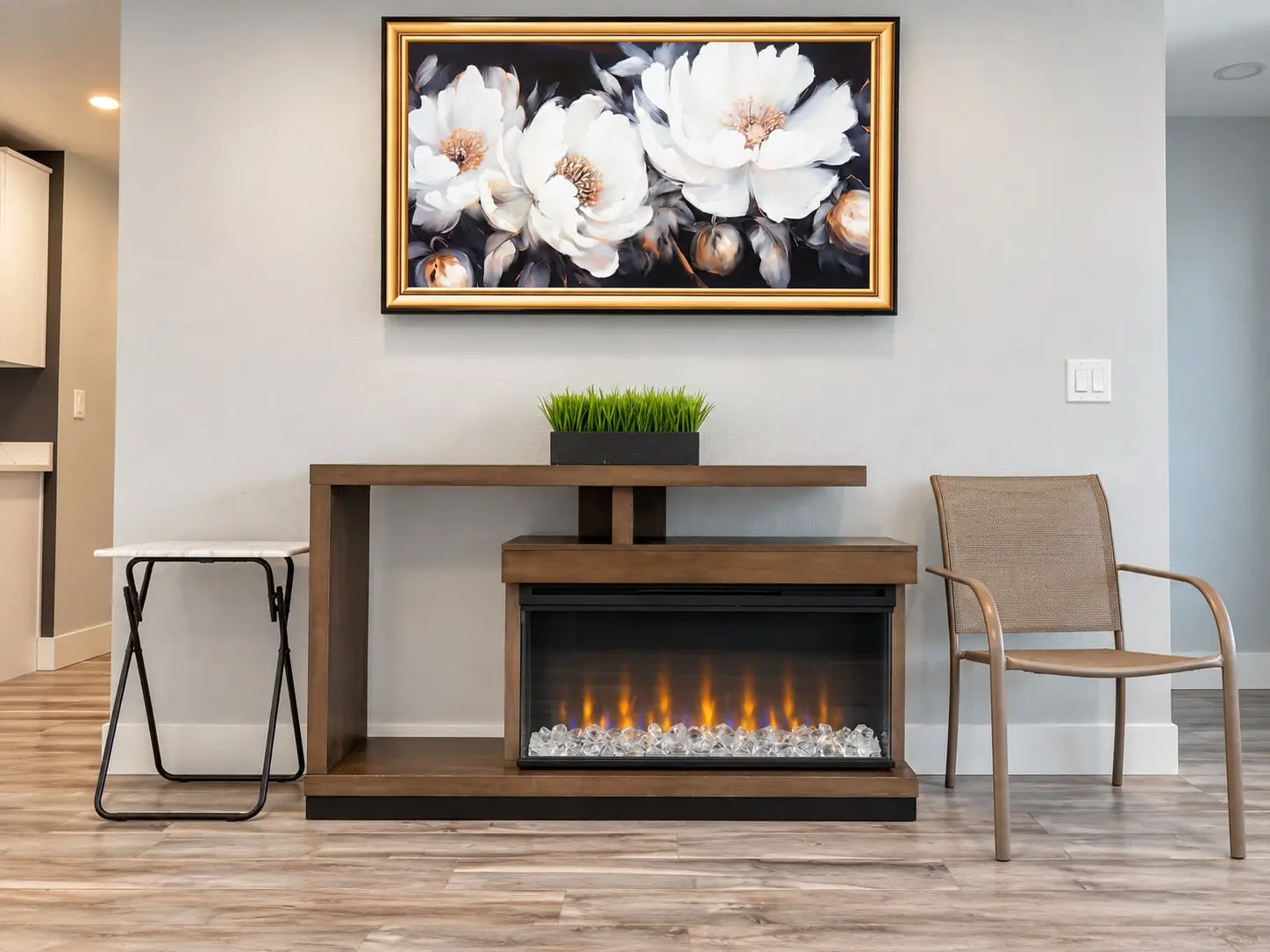 Electric fireplace console beneath a framed floral painting