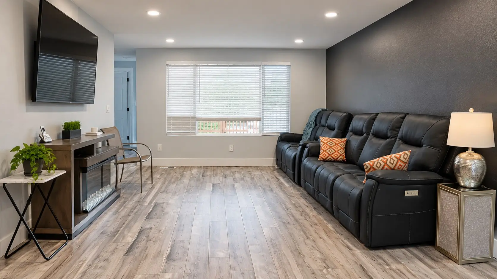 Living room with a leather sofa, table lamp and wood-look floors
